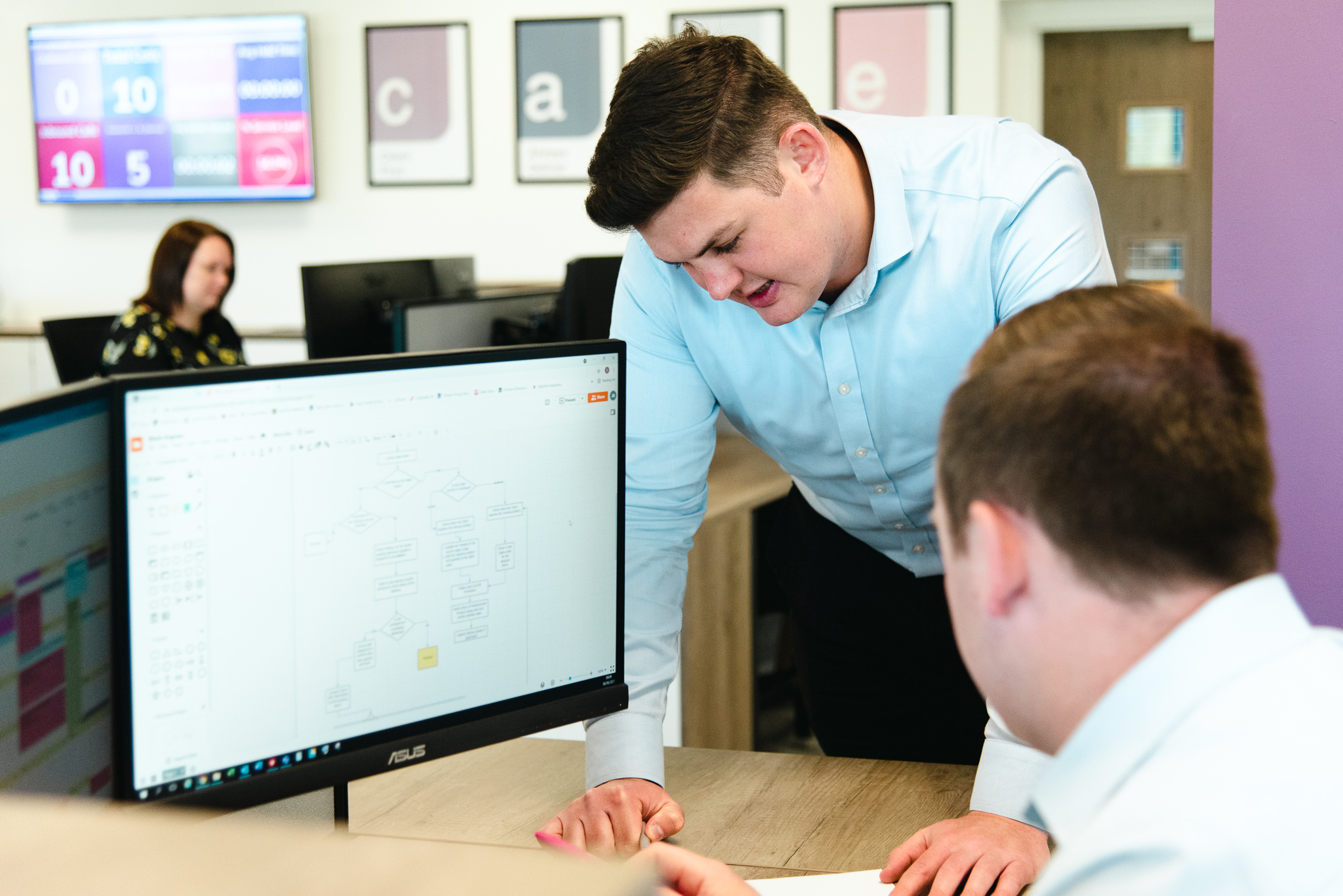 Two co-workers talking at a desk