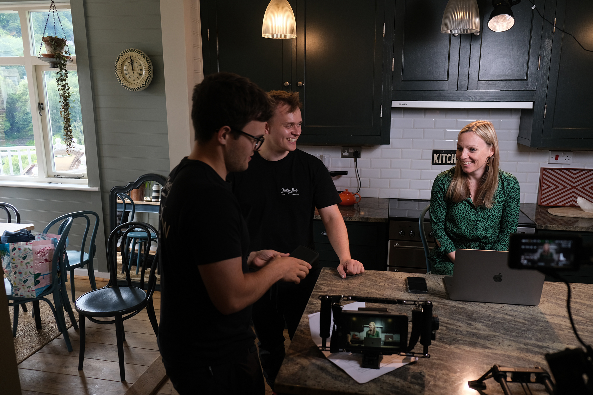 People gathered around a table, with equipment, discussing the film shoot