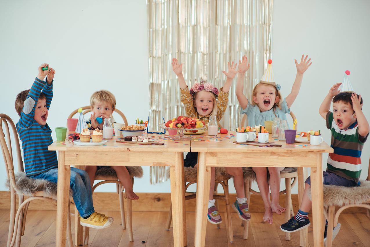 Children sat around a table cheering